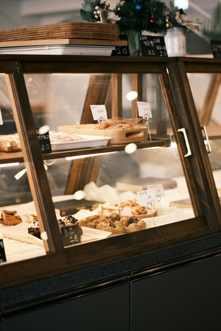 Explore a warm bakery with pastries beautifully displayed in a glass case.