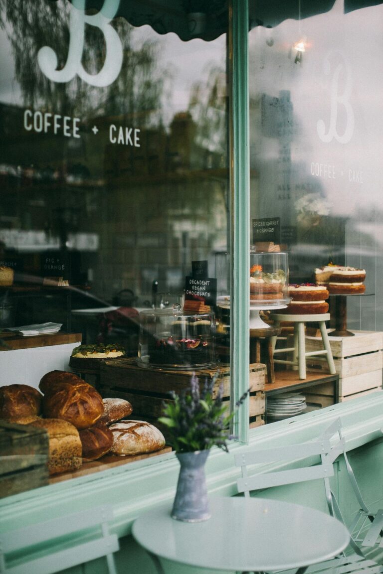 Warm and inviting cafe window display in Oxford showcasing fresh baked goods and cakes.